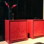 Two red cabinets with decorative pieces on top of them