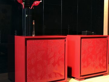 Two red cabinets with decorative pieces on top of them