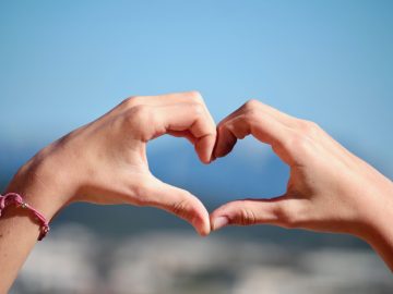 A person doing heart hand sign