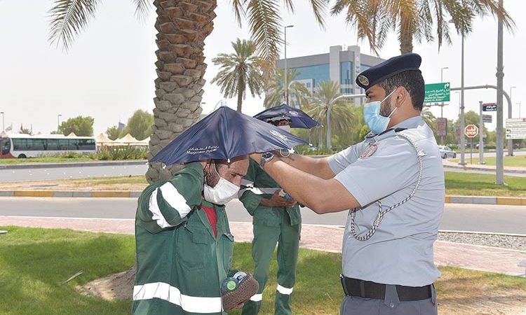 Workers in Abu Dhabi receive umbrella hats from Abu Dhabi Police